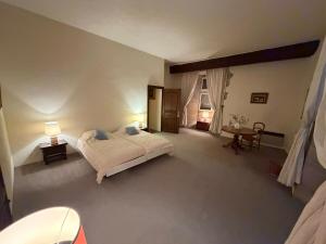 a bedroom with a bed and a table in it at Château de Savigny - Suite Eau in Savigny +22 photos