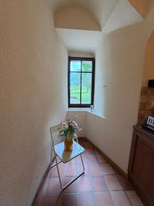a room with a table with a vase of flowers on it at Château de Savigny - Suite Eau in Savigny