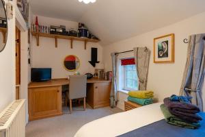 a bedroom with a bed and a desk and a computer at Number Eleven Unique Boutique in Great Gransden