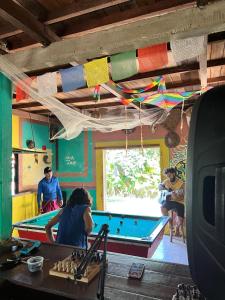 a group of children playing with a pool table at Hostel Bamaica Algodoal - Espaço Curupira in Algodoal +15 photos