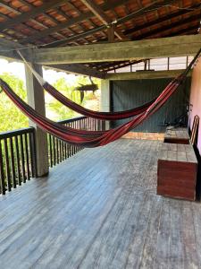 a hammock on a deck in a building at Hostel Bamaica Algodoal - Espaço Curupira in Algodoal