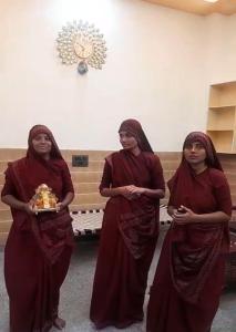 a group of three women standing in a room with a cake at Vallabh Kunj Sewa Sadan in Govardhan +20 photos