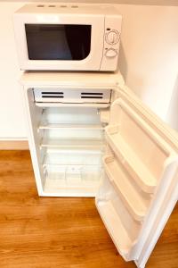 a microwave oven sitting on top of an open refrigerator at Escapade au Mont St Michel in Pleine-Fougères
