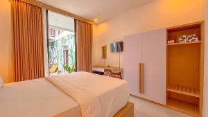 a bedroom with a white bed and a window at Agung Guest house Canggu in Dalung +35 photos
