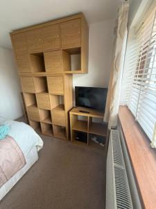a bedroom with a bed and a desk with a television at 16 Bentley Road - Uttoxeter, Comfortable accommodations, SHARED SHOWER ROOM, NO BREAKFAST in Uttoxeter