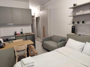 a room with a kitchen and a bed and a table at Parastaseis Central Studio Georges Sq in Patra