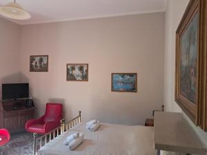 a bedroom with a bed and a red chair at RB Della Torre in Porretta Terme