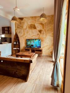 a living room with a large stone wall at Lala salama Kendwa villas in Kendwa