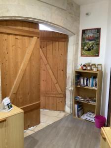 a wooden barn door in a room with a book shelf at Damvix Chambre d hôtes La Barbée in Damvix