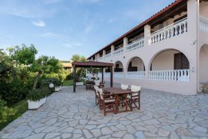 a patio with a table and chairs and a building at Boomerang Sea View Accommodation in Planos