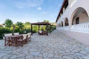 a patio with a table and chairs on a building at Boomerang Sea View Accommodation in Planos