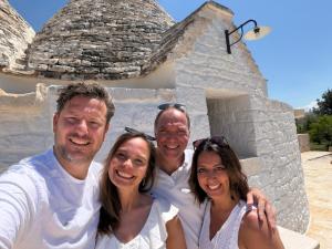 a group of people posing for a picture in front of a building at Luxury Trulli di Giulia, exclusive villa with private pool in Valle d'Itria Ostuni - BR, Puglia in Ostuni