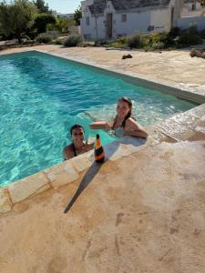 a man and a woman in a swimming pool at Luxury Trulli di Giulia, exclusive villa with private pool in Valle d'Itria Ostuni - BR, Puglia in Ostuni