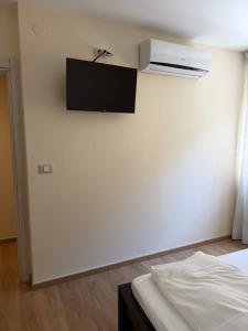 a bedroom with a tv on the wall and a bed at Appartamenti Camere Schaefer in Tarvisio