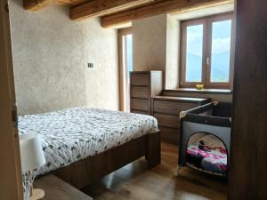 a bedroom with a bed and a window at Alloggio Bellavista in Rore +10 photos