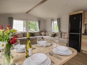 a living room with a table with plates and wine glasses at Jurassic Discovery in Charmouth