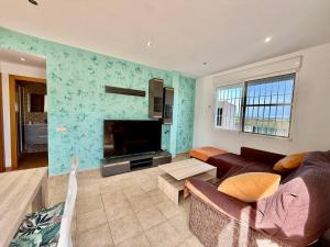 a living room with a couch and a flat screen tv at Los Olivos - Casa Adosada in Peniscola