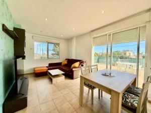 a living room with a couch and a table at Los Olivos - Casa Adosada in Peniscola