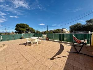 a patio with a table and chairs and a fence at Los Olivos - Casa Adosada in Peniscola