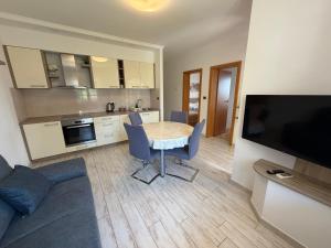 a living room with a table and a kitchen at Apartment Vrenjak in Portorož