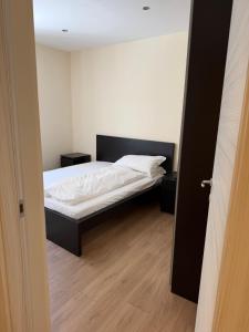 a small bedroom with a bed with white sheets at Appartamenti Camere Schaefer in Tarvisio +1 photo