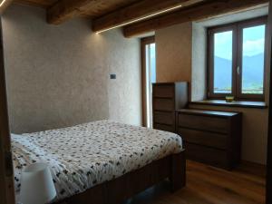 a bedroom with a bed and a window at Alloggio Bellavista in Rore
