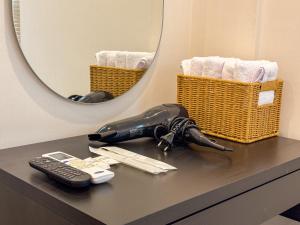 a bottle on a counter with a remote control and a mirror at 아문 스테이 in Busan