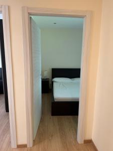 a bedroom with a door leading to a bed at Appartamenti Camere Schaefer in Tarvisio