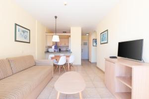 a living room with a couch and a flat screen tv at OBSIDIAN Granada Park in Arona