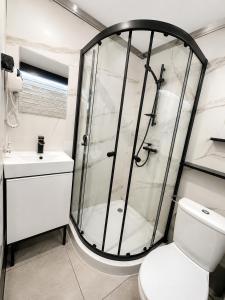 a bathroom with a shower and a toilet and a sink at Willa Fenix Busko-Zdroj Pokoje Goscinne & Agroturystyka in Busko-Zdrój +49 photos