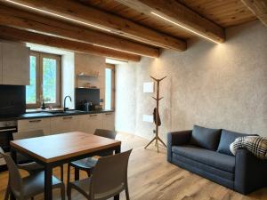a kitchen and living room with a table and a couch at Alloggio Bellavista in Rore