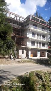 a large white building on the side of a road at Dholadhar Hotel & Restaurant in Barot  +16 photos