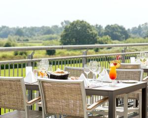 a table with wine glasses sitting on a balcony at PLAZA INN Hamburg Horner Rennbahn in Hamburg +26 photos