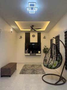 a living room with a ceiling fan and a couch at Azlynie Homestay in Kangar