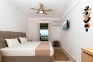 a bedroom with a bed and a ceiling fan at Boomerang Sea View Accommodation in Planos