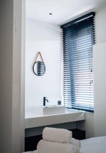 a white bathroom with a sink and a mirror at Vakantiewoning number 44 in Ieper +34 photos