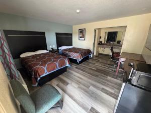 a hotel room with two beds and a desk at Village Inn in Ada