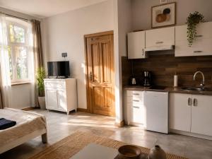 a kitchen with white cabinets and a table in a room at Apartamenty Sunny Bear in Jelenia Góra