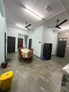 a room with a table and chairs and a kitchen at Homestay Anaza in Kampong Balai Maras +1 photo