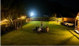a group of people sitting in a field at night at San Marcos Mountain Lodge in Chontabamba