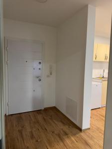 an empty room with white walls and wooden floors at Fiona's apartment in Gjakove