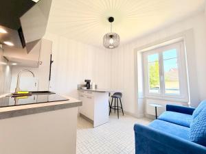 a kitchen and a living room with a blue couch at Appartement 2 prsn Proche Gare Viotte in Besançon