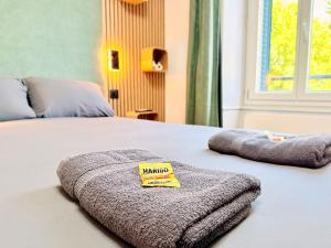 a bed with two towels on top of it at Appartement 2 prsn Proche Gare Viotte in Besançon