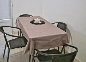 a table with four chairs with a pink table cloth at Kalma in Villa Elisa +2 photos