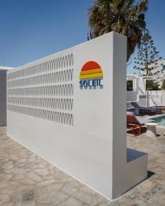 a white wall with a sign for a pool at Soleil Hotel Paros in Drios