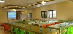 a conference room with tables and chairs and a screen at Lamu Creek Hotel in Lamu