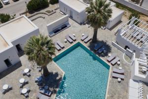 an overhead view of a swimming pool with lounge chairs and palm trees at Soleil Hotel Paros in Drios +63 photos