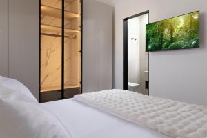 a bedroom with a bed with a television on a wall at דקוטה 11 Dakota in Eilat