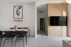 a dining room with a table and chairs and a tv at דקוטה 11 Dakota in Eilat