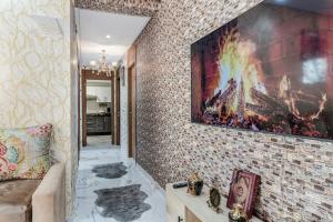 a living room with a large painting on a brick wall at Gated oceanfront residence - chic apartment in Salé